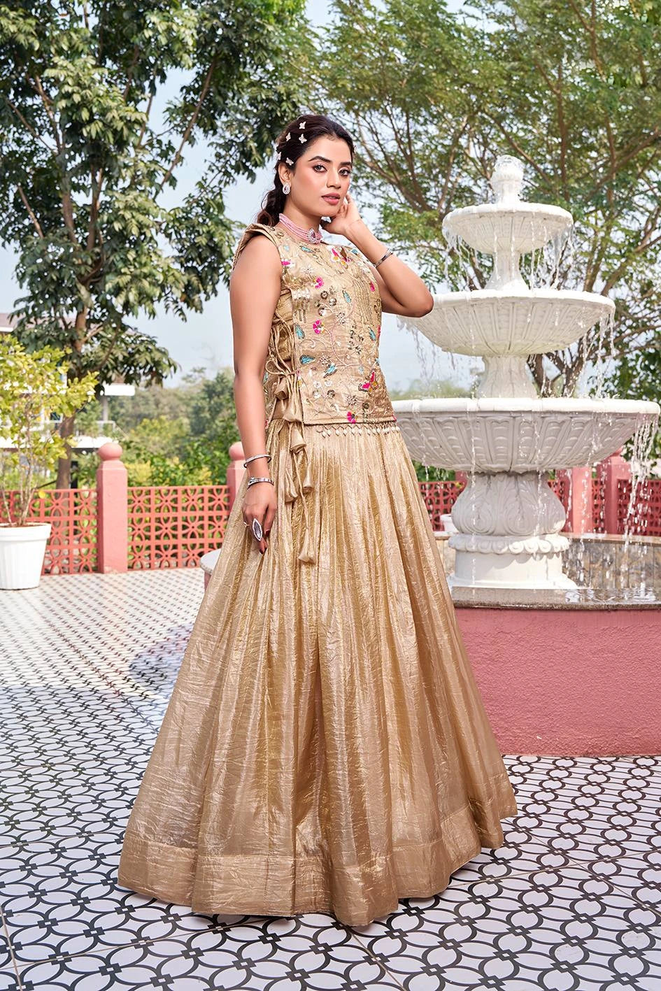 Woman in a traditional outfit standing in front of a fountain with trees in the background